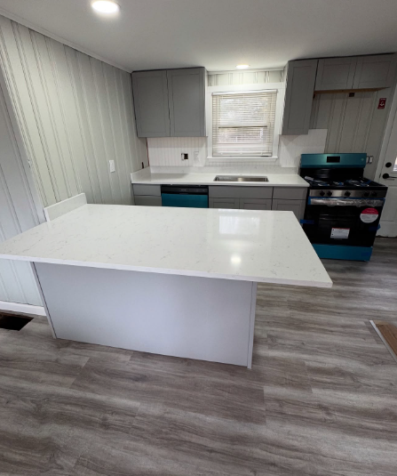 Renovated kitchen with a white quartz island and gray cabinets