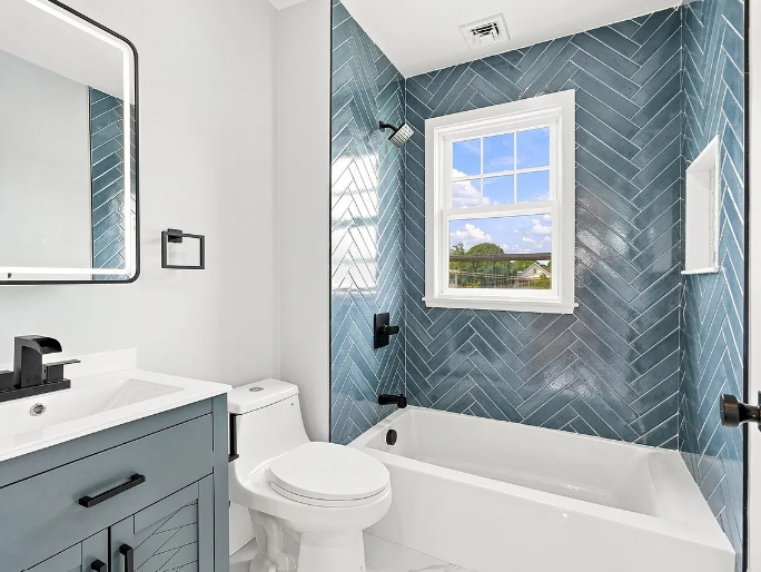 After — renovated bathroom with blue herringbone tile