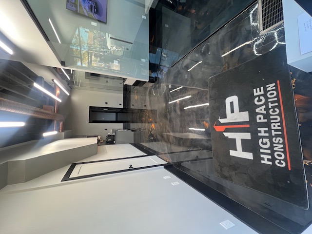 High Pace branded entrance mat and polished office floor beside the glass meeting room