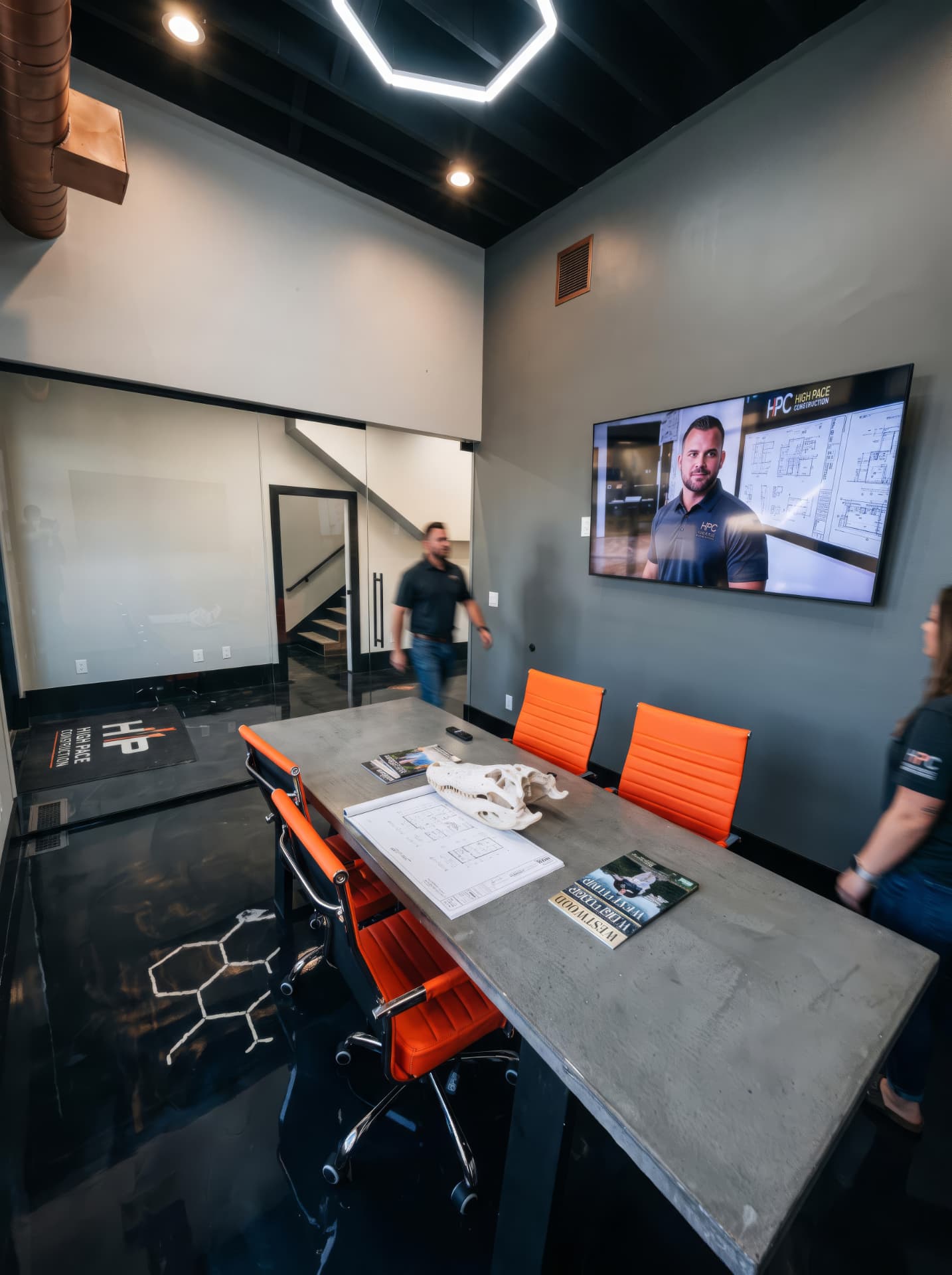High Pace office meeting room with a long table, orange chairs, and team members