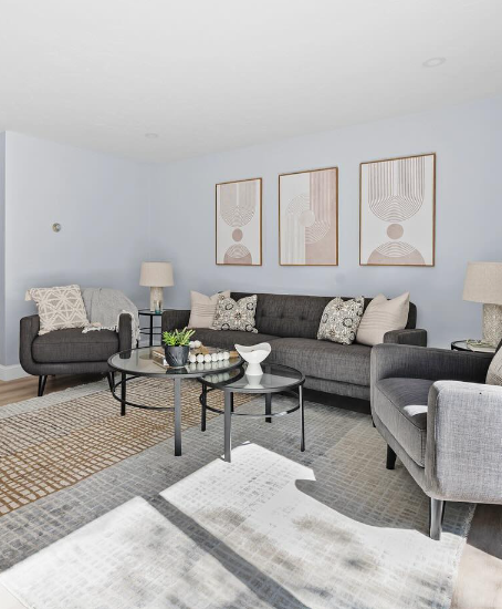 Finished living room with gray seating and layered rugs