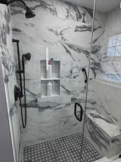 Marble wet room shower with herringbone mosaic floor