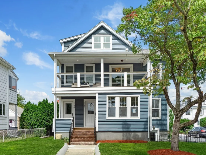 After — renovated blue-gray exterior with front porch