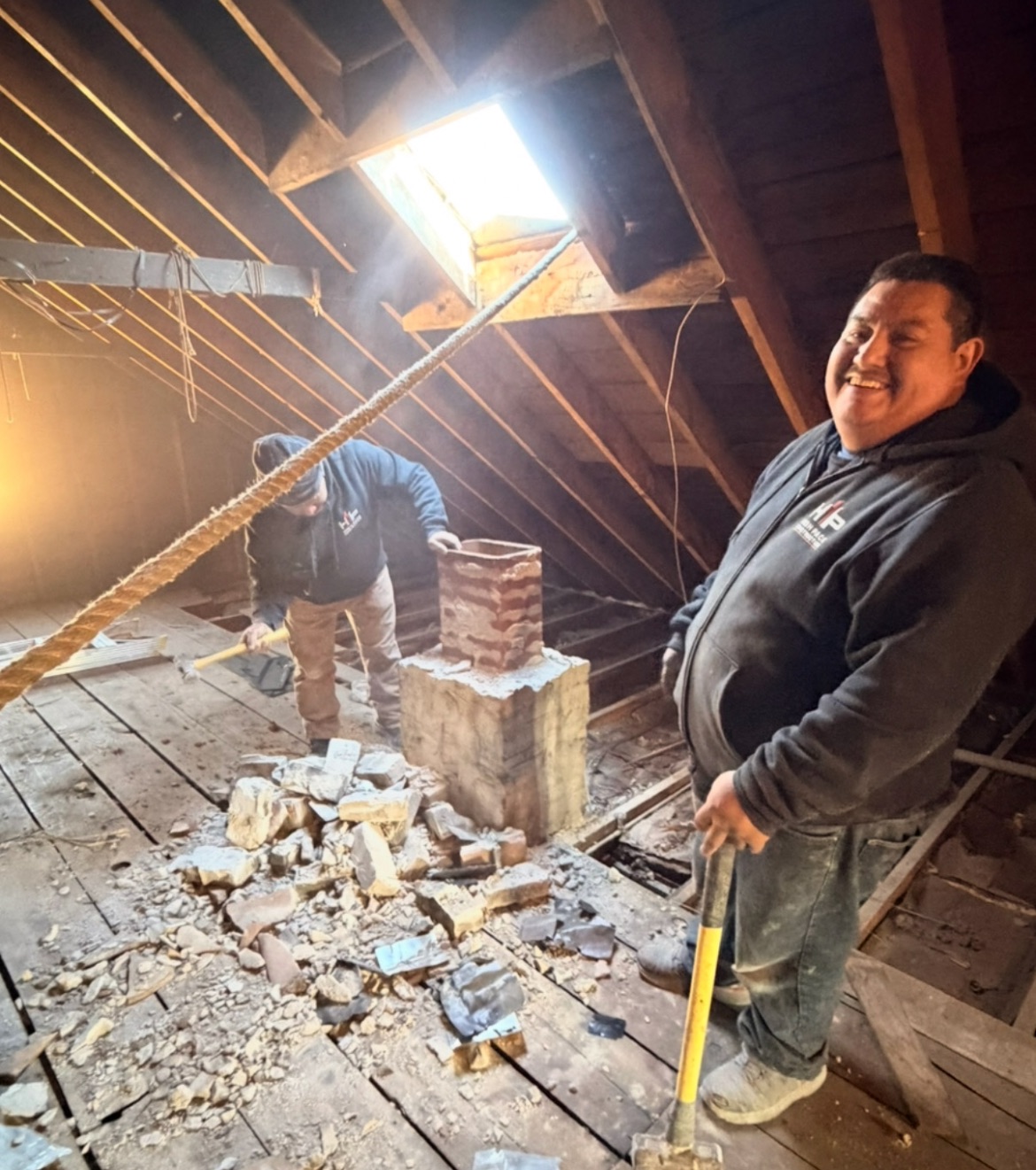 High Pace Construction crew removing a brick chimney inside an attic