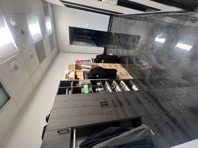 Office cabinets, open storage shelving, and hallway