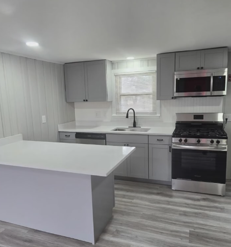 Renovated kitchen with gray cabinetry and white island