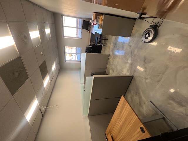 Office desks and partitions beneath ceiling lights