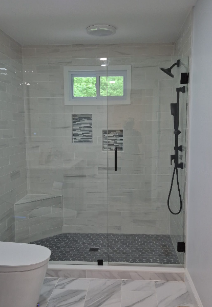 Walk-in shower with bench, window, and matte black fixtures